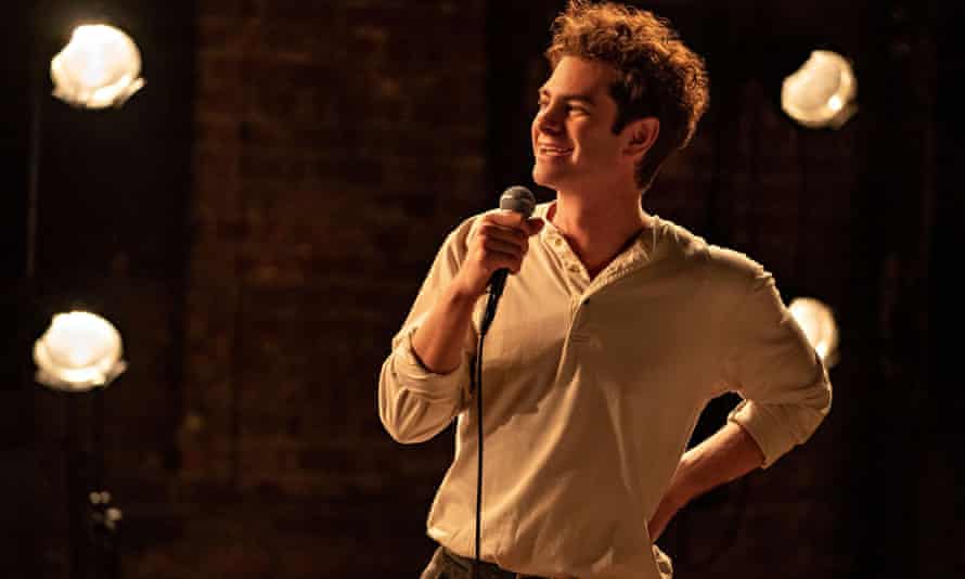 L'homme en chemise à col ouvert tient un microphone