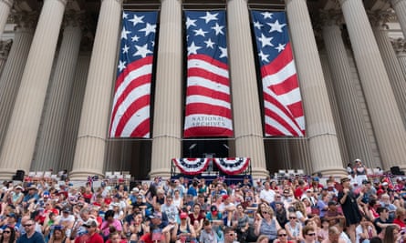 Parade-goers sit at the National Archives for the reading of the Declaration of Independence and the Independence Day parade along Constitution Avenue in Washington DC.