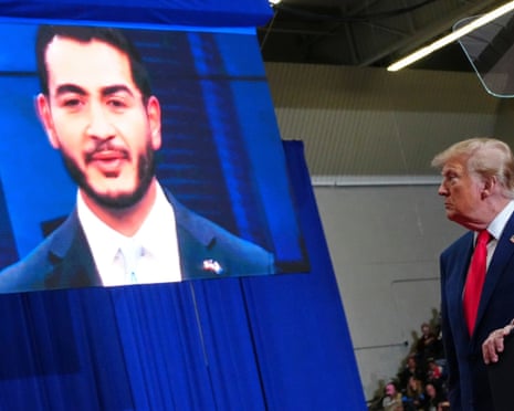 President Donald Trump looks at an image of Michigan Democratic senate candidate Abdul El-Sayed during a campaign rally
