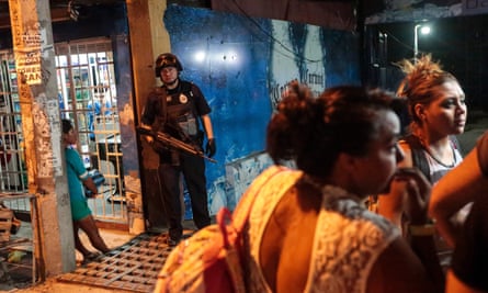 A Federal Police officer stands at the entrance of a bar where a man was shot dead by gunmen in Acapulco