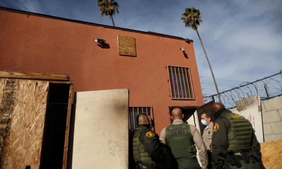 Los Angeles sheriff’s deputies walk up to a commercial building to carry out an eviction order, 13 January 2021. 