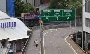 A couple walk down an empty street in Sydney
