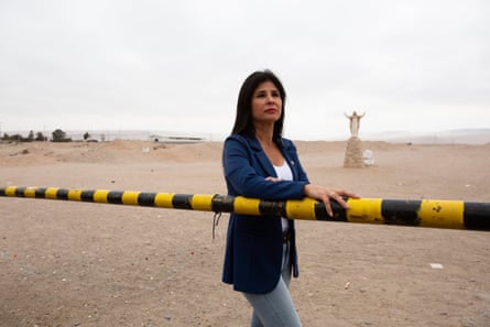 Pollyana Rivera leaning against a security barrier in an arid landscape