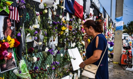 A woman prays as she visits a makeshift memorial where the partially collapsed Champlain Towers South building stood in Surfside, Florida.