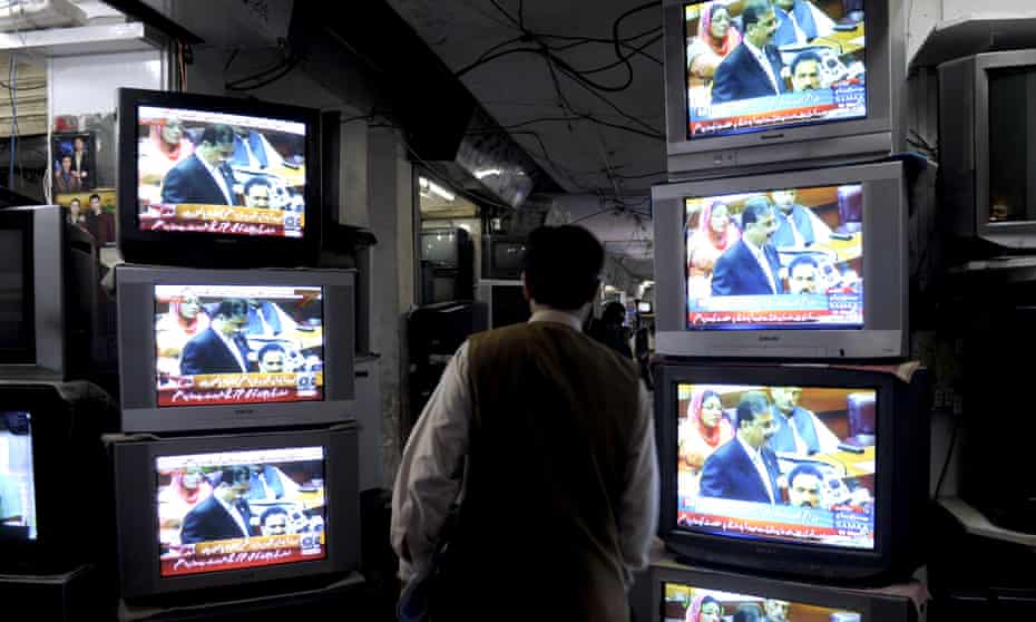 A Pakistani walks past  television sets