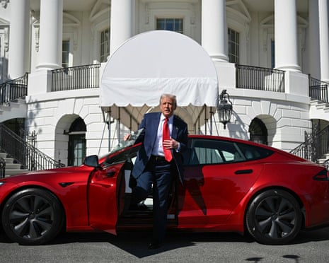 Trump in front of a red car