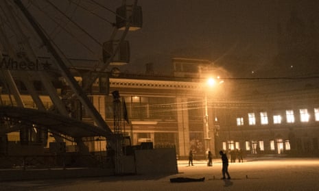 People walk as it snows in the city center of Kyiv, Ukraine, late Friday.