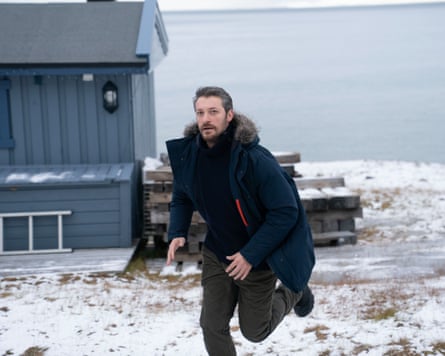 A man in a parka runs across snowy ground