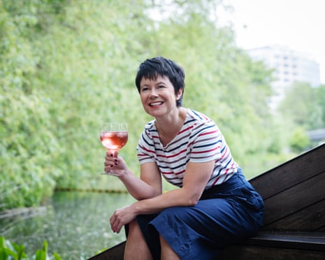 Rachel Dixon smiling and holding up a large bowl glass containing a pink drink
