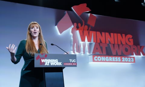 Angela Rayner speaking at a podium bearing the slogan 'Winning at work' - also repeated on the wall behind her