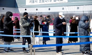 People wait in line to undergo the COVID-19 test at a temporary testing site set up in Seoul.