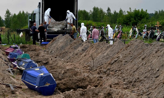 Municipal workers removed the body bags of about twelve unidentified citizens from the back of a mortuary container to place them in coffins ready for burial at a local cemetery in Bucha, Kyiv region.