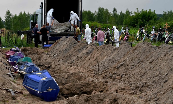 Municipal workers remove body bags of some twelve unidentified civilians from the back of a morgue container to be laid in coffins ready for burial at a local cemetery in Bucha, Kyiv region.