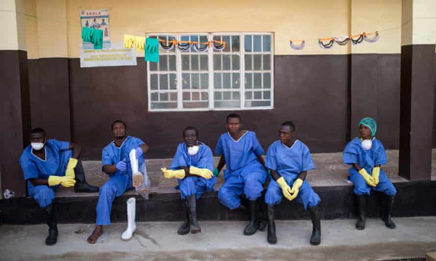 Health workers resting outside a quarantine zone at a Red Cross facility in the town of Koidu, Sierra Leone, in December 2014