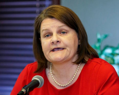 a woman in a red shirt speaks into a microphone