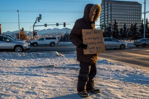Carl, a 28-year-old who has been homeless for most of his life, holds a sign on a corner in Anchorage, when the temperature remained in the single digits.