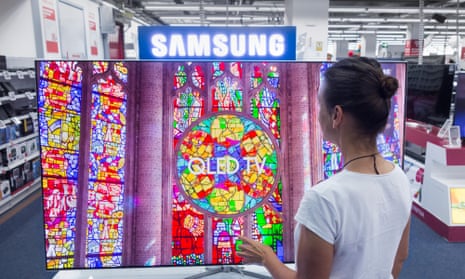A woman looking at Samsung QLED TV in an electrical store