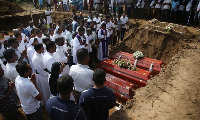 People attend a mass burial of victims at a cemetery near St Sebastian church in Negombo.