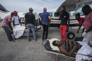 Residents injured by the 7.2 magnitude earthquake are taken on stretchers to a plane that will take them to the capital city of Port-au-Prince, from the airport in Les Cayes.