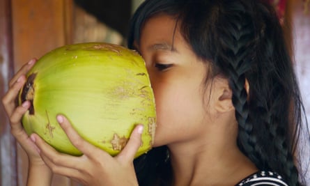 Better than butter? Maybe … a young girl drinking fresh coconut milk.