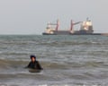 An Iranian woman enjoys a dip in the sea as vessels are seen in the Strait of Hormuz off the port city of Bandar Abbas, in southern Iran on 10 August.