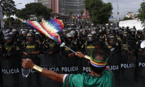 A man waves a flag of the indigenous peoples in front police in Lima as anti-government protests continued across Peru.