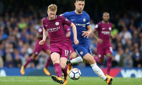 Kevin De Bruyne plays a pass under pressure from Chelsea’s Gary Cahill. 