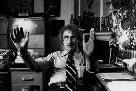 Psychologist John Money speaking and gesturing while sat at a desk