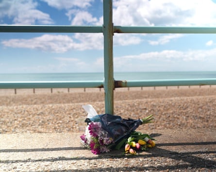 Flowers next to railings beside the beach.
