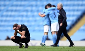 West Ham United’s Vladimir Coufal is dejected at the final whistle as manager David Moyes looks on in the distance and the Manchester City players celebrate their victory.