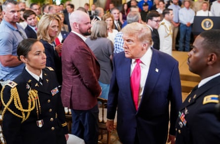 a man in a suit walks among a crowd of people