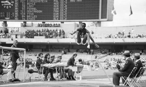 Black and white image of Bob Beamon mid-jump as he breaks the long jump world record in 1968