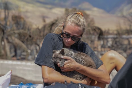 US-FIRE-HAWAIIA woman cradles her cat after finding him in the aftermath of a wildfire in Lahaina, western Maui, Hawaii on August 11, 2023.