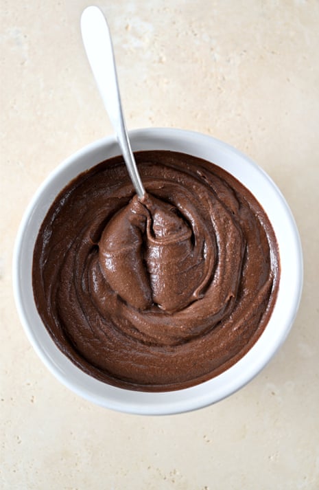 A bowl of chocolate mousse and a spoon