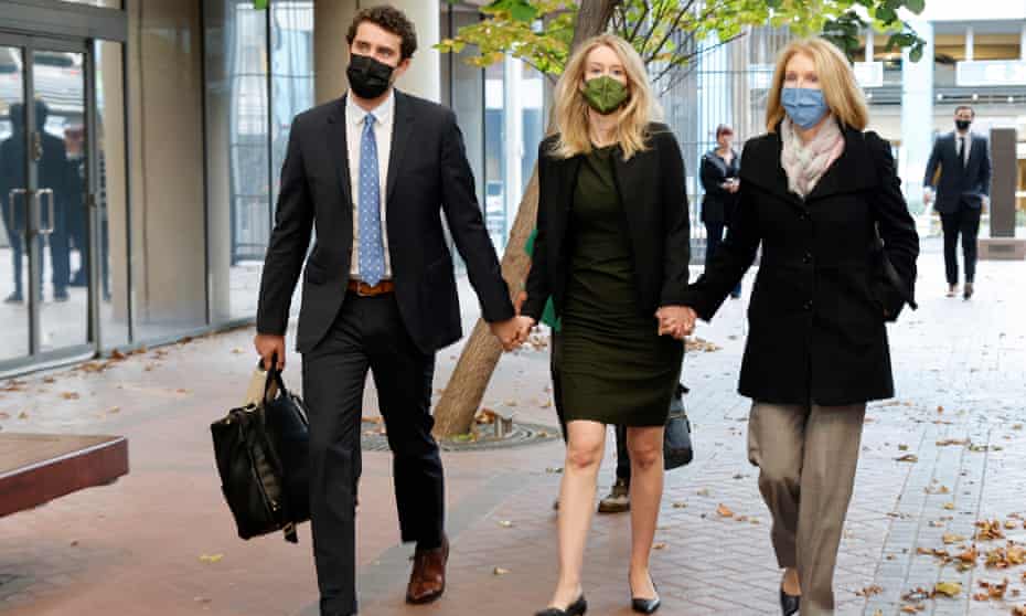 Theranos founder Elizabeth Holmes, flanked by her husband and her mother, arrives at the courthouse in San Jose on 12 October 2021.