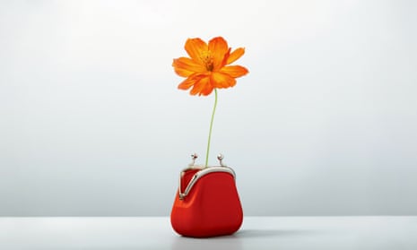 A purse with a single orange flower emerging from it