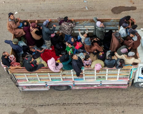 This aerial view shows evacuating members of the Bedouin community riding atop a truck moving along a road in Taarah, in Syria’s southern Sweida province on the way to Daraa, on 21 July 2025.