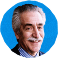 man in suit smiling against blue background