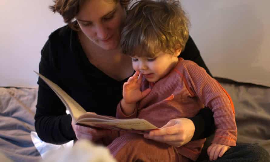 Mother reads to toddler in her lap