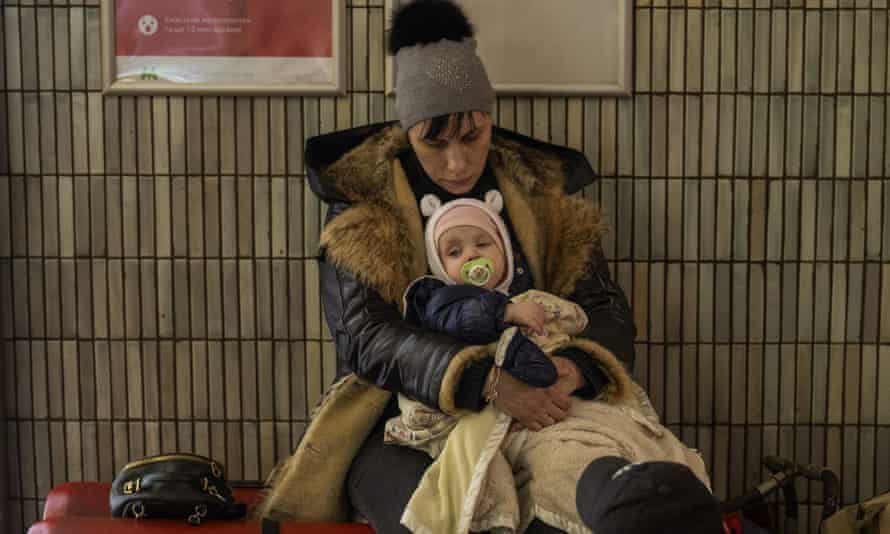 Fear, darkness and newborn babies: inside Ukraine’s underground shelters 4 A family sit in the Kyiv subway, using it as a bomb shelter