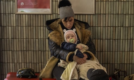 A family sit in the Kyiv subway, using it as a bomb shelter