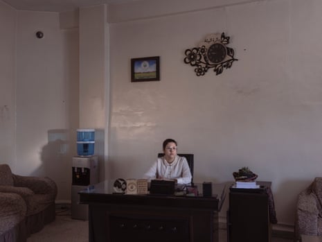 A woman sits at a desk in an office