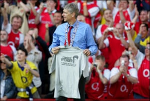 The team acquired the nickname “The Invincibles”, and the club was awarded a golden replica trophy by the Premier League once the season concluded and they remained unbeaten for 49 games, setting a new record. Arsène Wenger is pictured during the celebrations after the Leicester game holding a t-shirt produced the year before, mocking his prediction that Arsenal could go the whole season unbeaten.