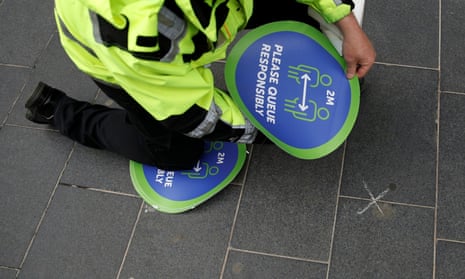 A worker attaching social distancing marking to the pavement in Liverpool today.