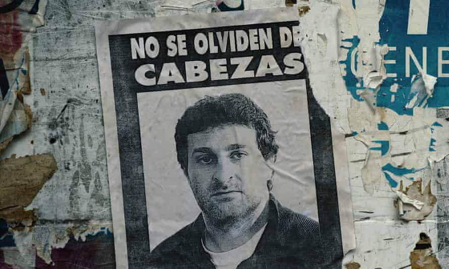 A poster saying ‘Don’t forget Cabezas’ in The Photographer: Murder in Pinamar.