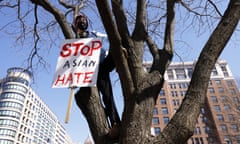 An activist holds a sign on a tree during a “DC Rally for Collective Safety - Protect Asian/AAPI Communities” at McPherson Square March 21, 2021 in Washington, DC.