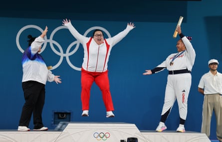 China’s gold medallist Li Wenwen leaps on the podium as she is congratulated by Park Hye-jeong (left) and Emily Campbell.