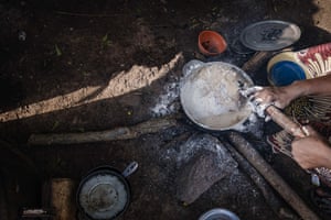 A cooking pot is stirred over an open fire.