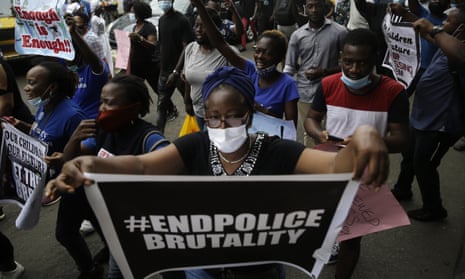 Woman in crowd holds 'end police brutality' sign