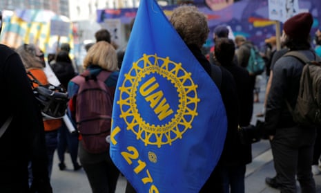 A person carries a UAW flag during a May Day rally in New York City. 
